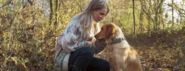 kvinne og hund i skogen